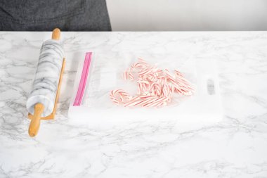 Nane şekerlerini beyaz bir kesim tahtasının üzerinde mermer bir raptiyeyle plastik bir çantada ezmek..