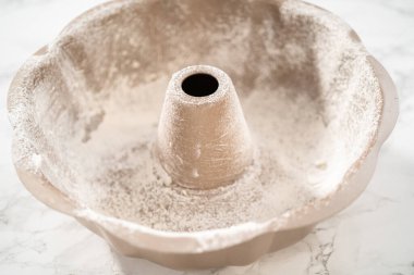 Kek pişirmek için metal tepsiyi yağlamak.