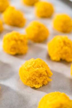 Beyaz çikolatalı limonlu kurabiye. Beyaz çikolatalı limonlu kurabiye pişirmek için parşömen kağıdıyla kaplı bir yemek tepsisine hamur kepçesiyle kurabiye pişirmek..