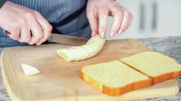 近代的なホワイトキッチンでは バターバナナとブリオッシュパンはおいしいグリルピーナッツバターバナナサンドイッチを作るために準備されています — ストック写真
