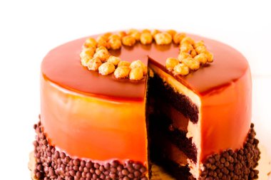 gurme çikolata, fındık ve beyaz zemin üzerine karamelli pasta.