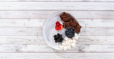 Arranging fruit smores charcuterie board on a white tray.