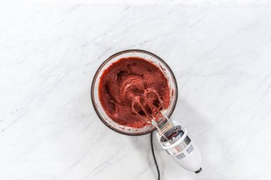 Düz yatıyordu. Kırmızı kadife kek ve krem peynir jöleli kek yapmak için büyük bir bardakta karıştırma malzemesi..