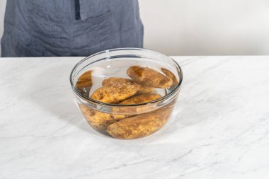 Fırında pişmiş patates. Bardakta çiğ patates yıkıyorum. Suyla karıştırıyorum..