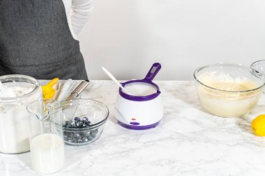 Kek kalıbı için yapışmaz bir yüzey oluşturmak için sebze kısaltma nazikçe eritilir ve unla harmanlanır..