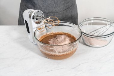 Kırmızı kadife kek ve krem peynir jöleli kek yapmak için büyük bir bardakta karıştırma malzemesi..