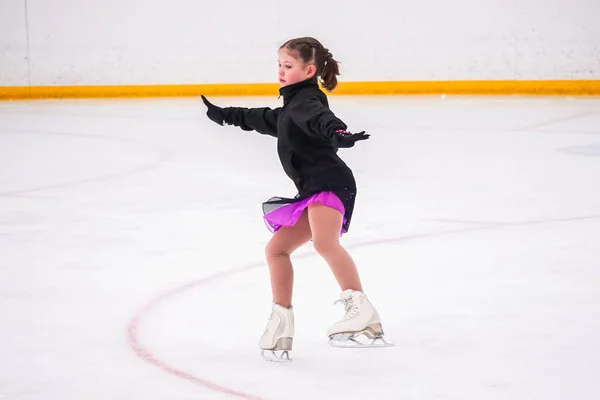 stock image Little girl practicing before her figure skating competition at the indoor ice rink.