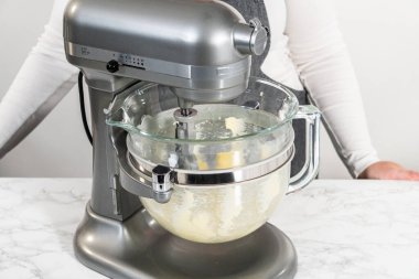 Mixing ingredients in kitchen electric mixer to bake American flag mini cupcakes.