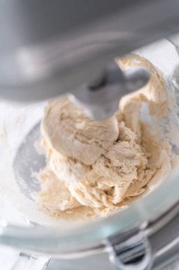 Büyük bir bardaktaki malzemeleri karıştırıyorum. Pizza hamuruyla karıştırıyorum..