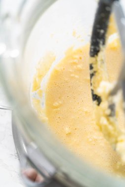 Mixing ingredients in kitchen electric mixer to bake American flag mini cupcakes.