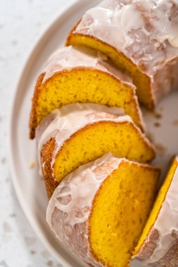 Dilimlenmiş vanilyalı kek, beyaz bir tabakta beyaz jöleli..