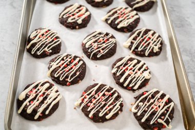 Taze pişmiş çikolatalı kurabiyeler ve üzerine nane şekeri serpiştirilmiş beyaz çikolata..