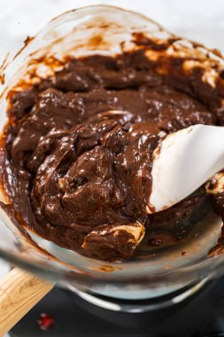 Eriyen beyaz çikolata parçaları ve diğer malzemeler kaynamış suyun üzerine karıştırıp çubuk şekerleme hazırlıyor..