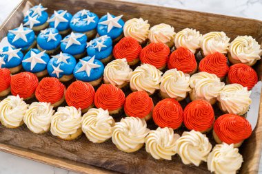 Arranging mini vanilla cupcakes in the shape of the American flag.