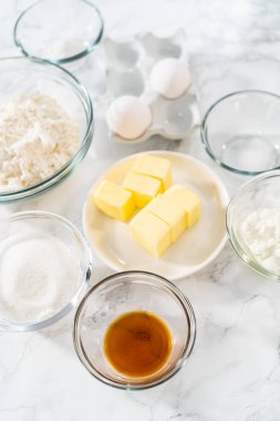 Bardaktaki ölçülü malzemeler mini vanilyalı kekler pişirmek için karıştırma kabı ve ombre pembe kremalı krema..