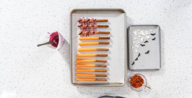 Düz yatıyordu. Çubuk krakerleri erimiş çikolataya batırıp Cadılar Bayramı 'nda çikolata kaplı çubuk kraker yapmak..