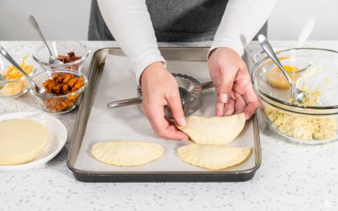 Börek hamurunu yumurta dolmasıyla doldurarak kahvaltıda yumurta ve tatlı patatesle börek yapmak..