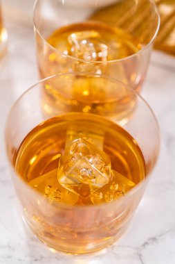 Buzlu viski, viski bardağında, beyaz mermer yüzeyde..