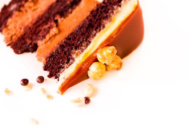 gurme çikolata, fındık ve beyaz zemin üzerine karamelli pasta.