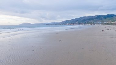 Güneş batarken Pismo Sahili, içi boş, kumlu kumlu, altın renklerle dolu büyüleyici bir kış harikalar diyarına dönüşüyor. Dalgaların huzur veren sesleri,