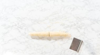 Düz yatıyordu. Tarçın ile doldurulmuş rulo ekmek hamuru ve daha küçük rulolara doğranmış fındıklar tarçınsız kek pişirmek için..