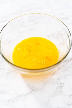 Küçük Paskalya ekmeği pişirmek için ıslak malzemeleri büyük bir bardakta karıştırıyorum..