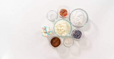 Düz yatıyordu. Tek boynuzlu atı sıcak çikolata yapmak için cam karıştırma kaselerinde ölçülmüş malzemeler..