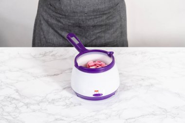 Çikolata, sıcak çikolata bombaları hazırlamak için bir şeker tenceresinde erir..