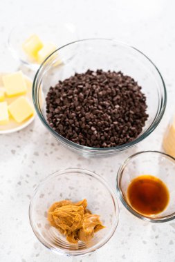 Fıstık ezmeli çikolata yapmak için cam karıştırma kabında ölçülmüş malzemeler..