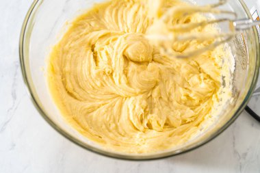 Limonlu yaban mersinli kek yapmak için büyük bir bardakta karıştırma malzemesi..