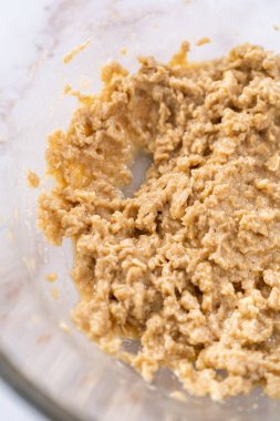 Elmalı yulaflı kurabiye pişirmek için büyük bir bardakta karıştırma malzemesi..