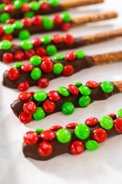 Denver, Colorado, ABD-18 Aralık 2022 eritilmiş çikolataya çubuk kraker ve çikolata kaplı çubuk çubuk kraker yapmak için şeker serpiştirme.