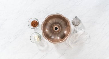 Düz yatıyordu. Bitkisel kısaltmalı yağlı metal kek tavası ve karamel dolu zencefilli kek pişirmek için kakao tozu..