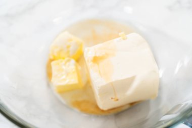 Büyük bir karıştırma kabında, malzemeler havuçlu kek için nefis krem peynirli tereyağı yapmak için ustalıkla karıştırılır..