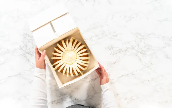 The Carrot Bundt Cake is carefully packaged into a white paper bundt cake box, ready for gifting or sharing.