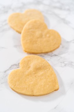 Sevgililer Günü için pembe ve beyaz kraliyet kremalı kalp şeklinde kurabiyeler..