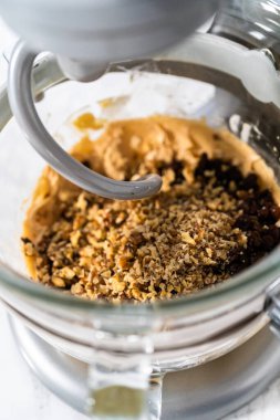 Yumuşak yulaflı kuru üzümlü cevizli kurabiyeler pişirmek için mutfak tezgahında karışımlar hazırlıyorum..