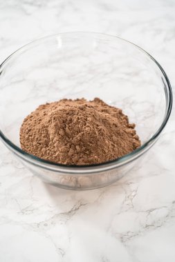 Büyük bir bardaktaki malzemeleri karıştırarak naneli çikolatalı kekler pişiriyorum..