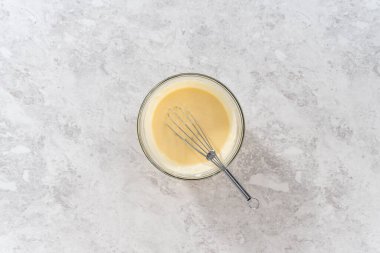 Düz yatıyordu. Küçük bir bardakta ıslak malzemeler karıştırmak havuçlu kek yapmak için krem peynirli pasta.