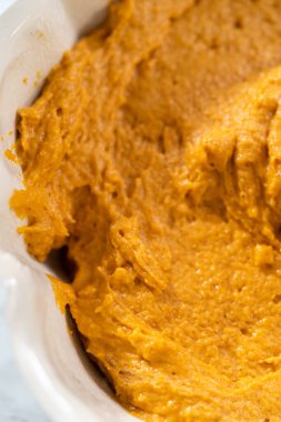 Balkabaklı kek pişirmek için yağlı kek tepsisine pasta hamuru döküyorum..