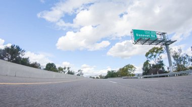 Açık bir kış gününde, bir araba, Santa Maria, California yakınlarındaki 101. Otoyol boyunca yeşil ve altın renkli bir karışımla çevrili, parlak mavi bir gökyüzünün altında sorunsuzca seyahat eder..