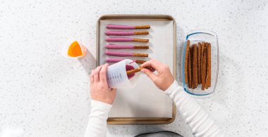 Düz yatıyordu. Çubuk krakerleri erimiş çikolataya batırıp Cadılar Bayramı 'nda çikolata kaplı çubuk kraker yapmak..