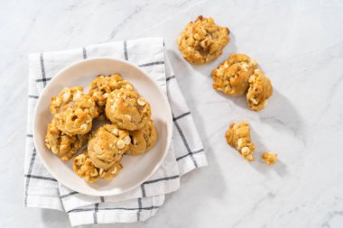 Beyaz bir tabakta taze pişmiş beyaz çikolatalı macadamia fındığı..