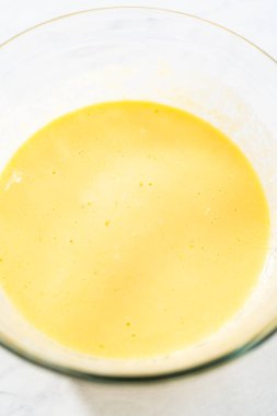 Kırmızı kadife kek ve krem peynir jöleli kek yapmak için büyük bir bardakta karıştırma malzemesi..