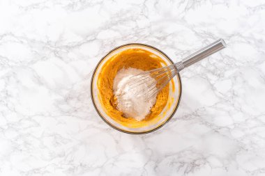 Düz yatıyordu. Büyük bir bardakta karışımı karıştırarak çikolatalı kabaklı kek ve karamel karışımı..