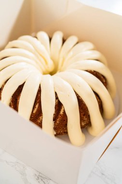 Taze pişmiş kekler beyaz kağıt kutulara dikkatlice yerleştirilir ve lezzetli görünümlerini korurken onları güvenli bir şekilde ulaşıma hazırlarlar..