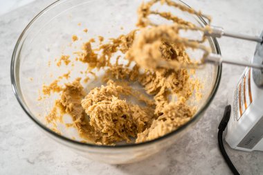 Büyük bir bardaktaki malzemeleri mutfak mikseriyle karıştırıp çikolatalı kurabiyeleri naneli cipsle pişirmek..