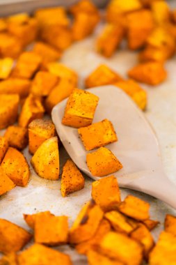 Beyaz seramik bir kasede fırında tatlı patates servis ediyorum..