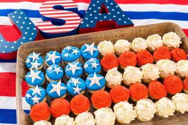 Arranging mini vanilla cupcakes in the shape of the American flag.