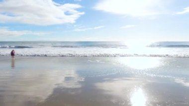 California 'da bir baba ve kızı, El Capitan Eyalet Plajı' nın ıssız kumları boyunca sakin bir kış yürüyüşünü paylaşıyor..